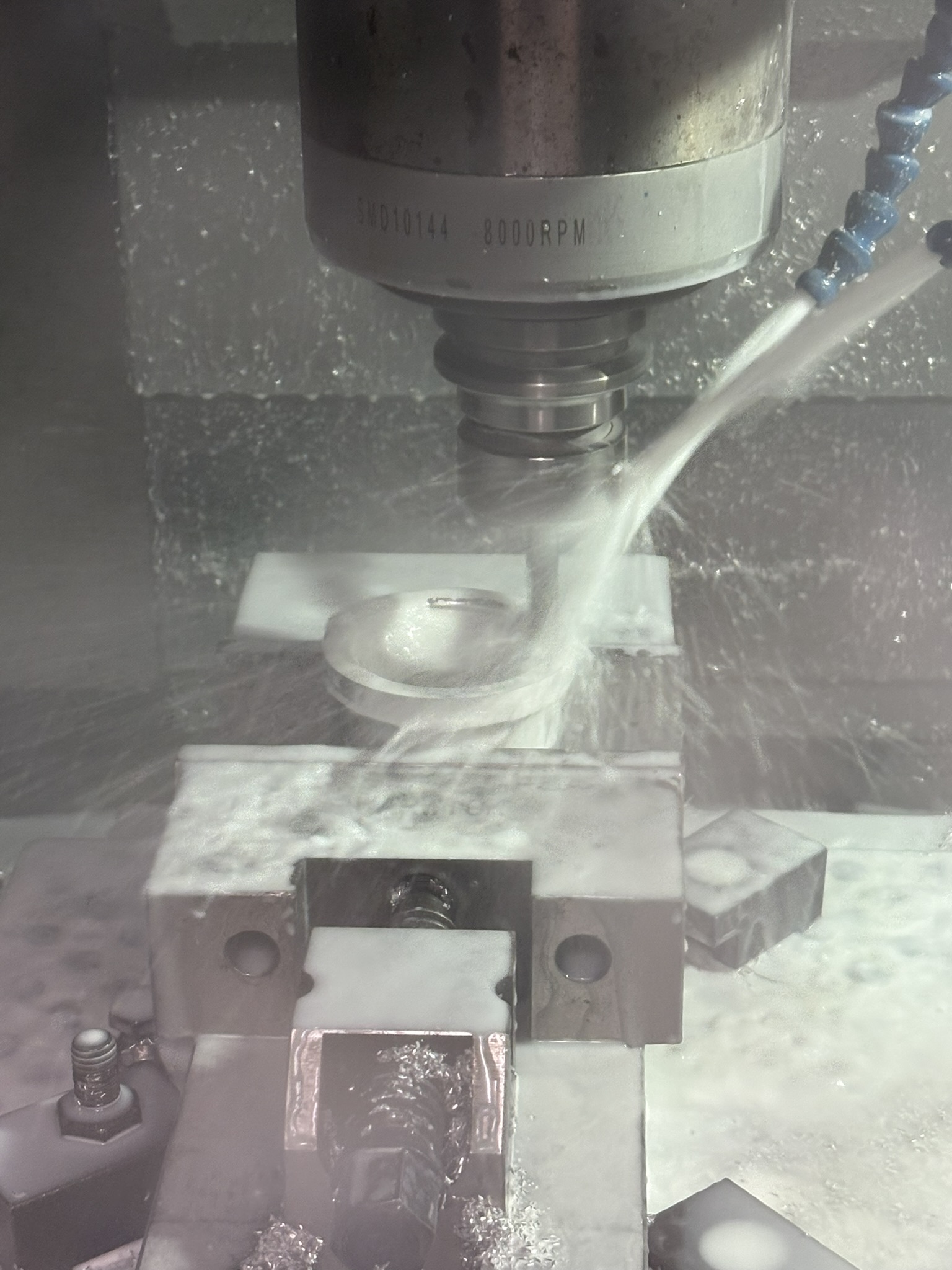 An aluminium component being milled with coolant